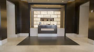 A reception area with a marble counter, dark walls, and recessed lighting.