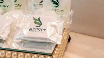 Una bandeja con varios paquetes identificados con la etiqueta 'Suntory business hotel' sobre una superficie de mármol.