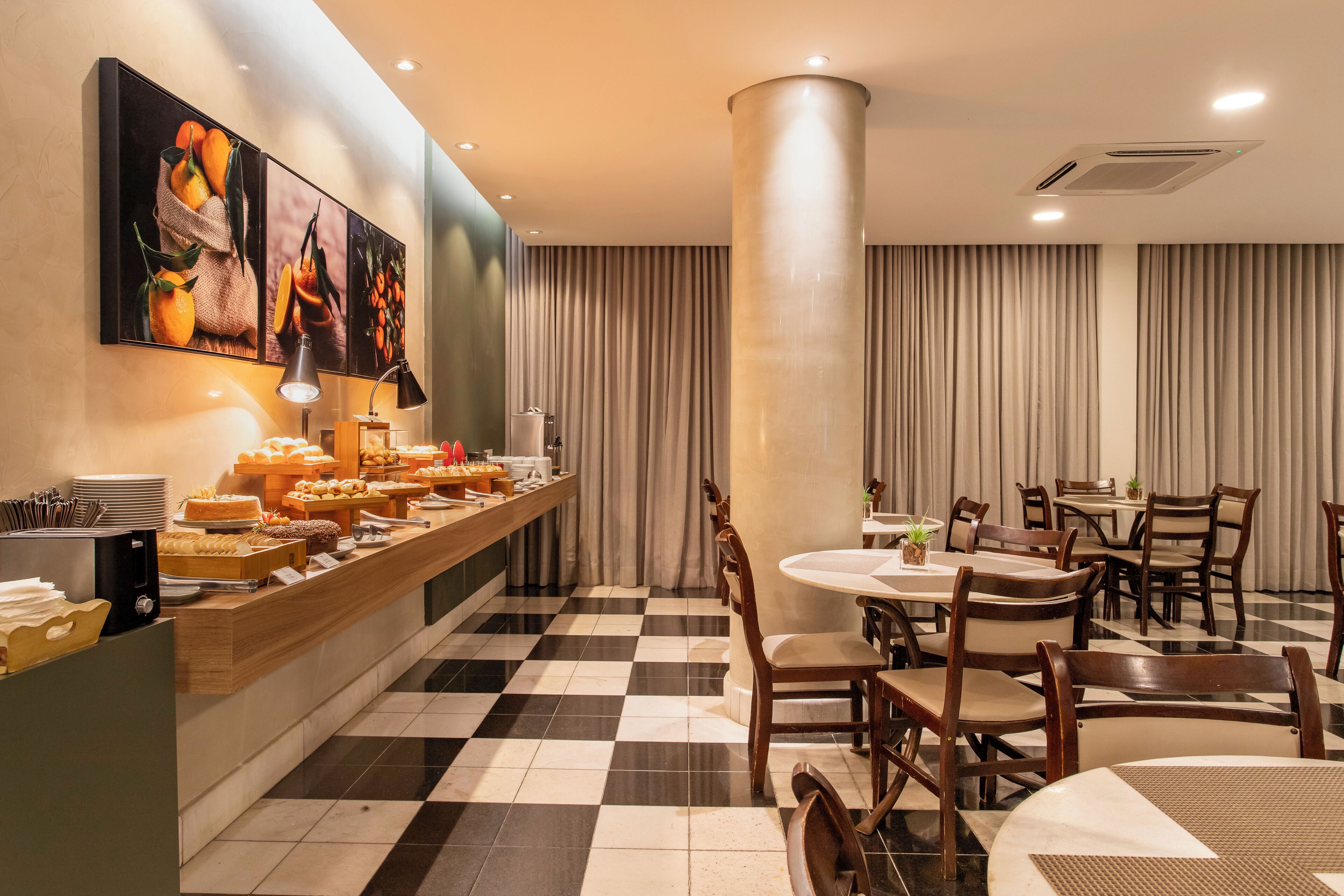 Un comedor de hotel con barra libre, piso a cuadros y un pilar grande.