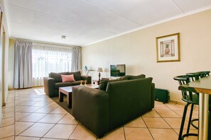 Perhehuoneisto (1 Bedroom) | Oleskelualue | 32–tuumainen taulutelevisio, jossa satelliittikanavat