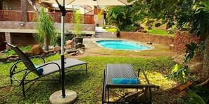 Alberca al aire libre y camastros 