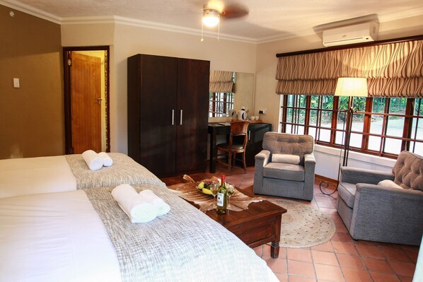 A hotel room with two beds, a desk, a chair, and a sofa. - Woodlands Guest House Hazyview (Mbombela)