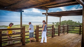A wooden deck with a view of a body of water and distant land. - At Heritage House (St. Lucia)
