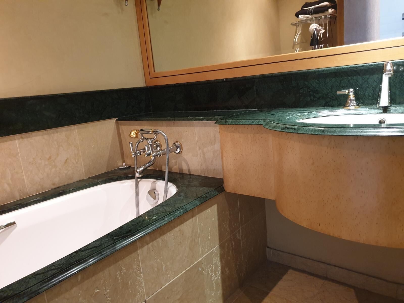 A bathroom with a bathtub, a sink, and a mirror.