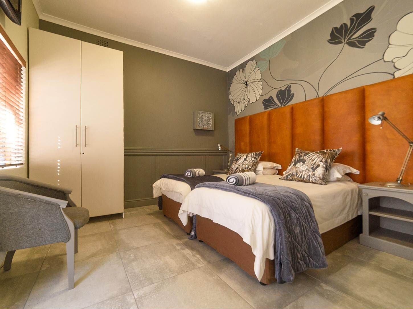 Une chambre avec deux lits, un bureau et une armoire.