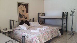 A single bed with a floral bedspread, a headboard, and a painting of a horse.
