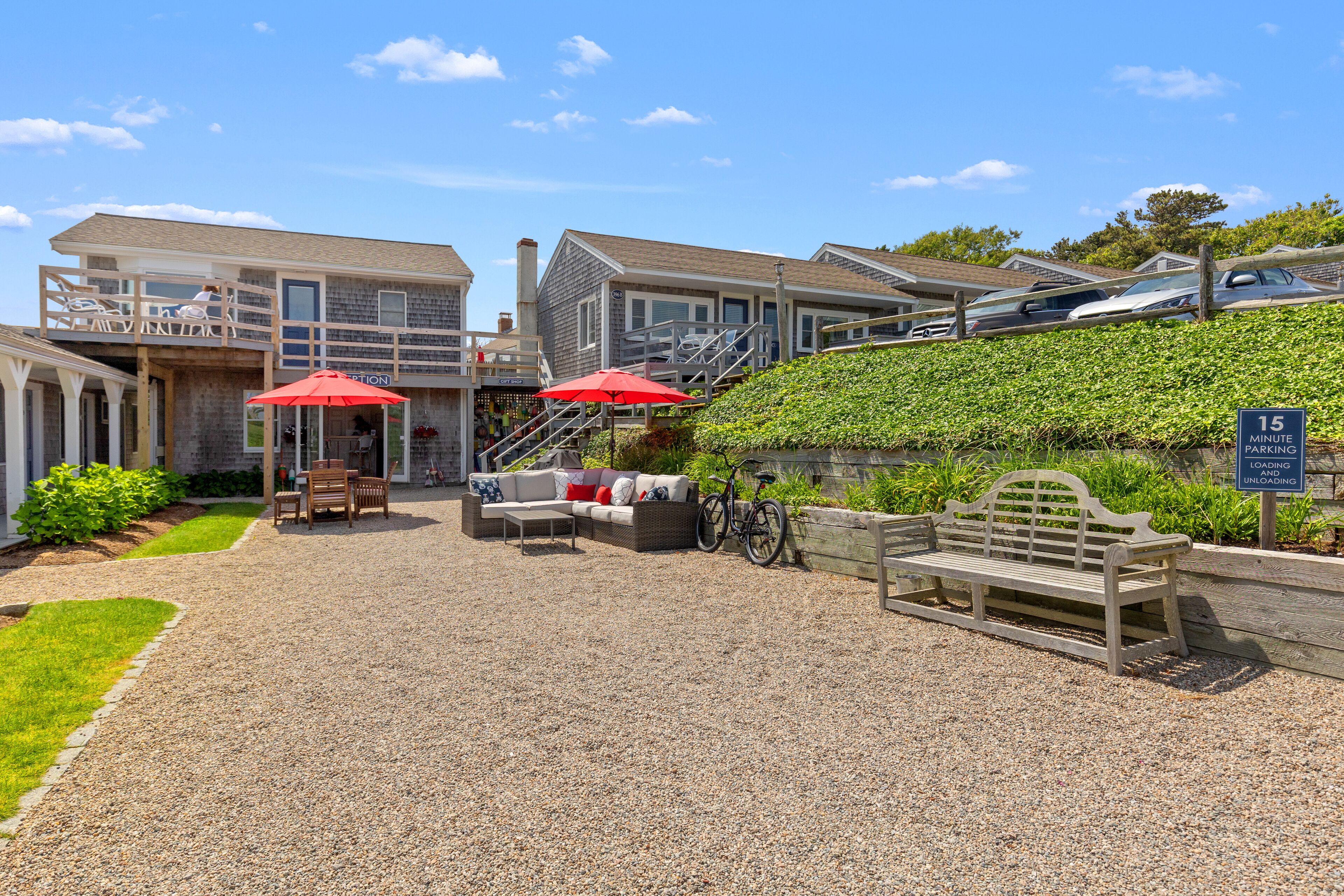A hotel with outdoor seating, a bicycle, and a parking sign.