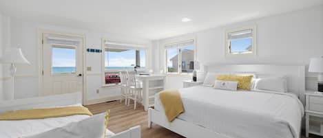 Una habitación de hotel con cama, escritorio y vistas al mar.