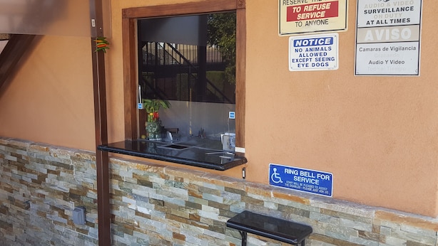A building exterior with a stone wall, a window, and multiple signs including a 'Notice No Animals Allowed Except Seeing Eye Dogs' sign.