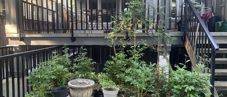 A balcony with a garden, outdoor furniture, and a staircase.