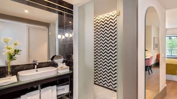 Un baño moderno con un espejo grande, dos lavamanos y un mueble de tocador con toallas.
