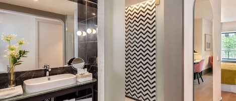 Une salle de bain moderne avec un grand miroir, deux lavabos et un meuble-lavabo agrémenté de serviettes.