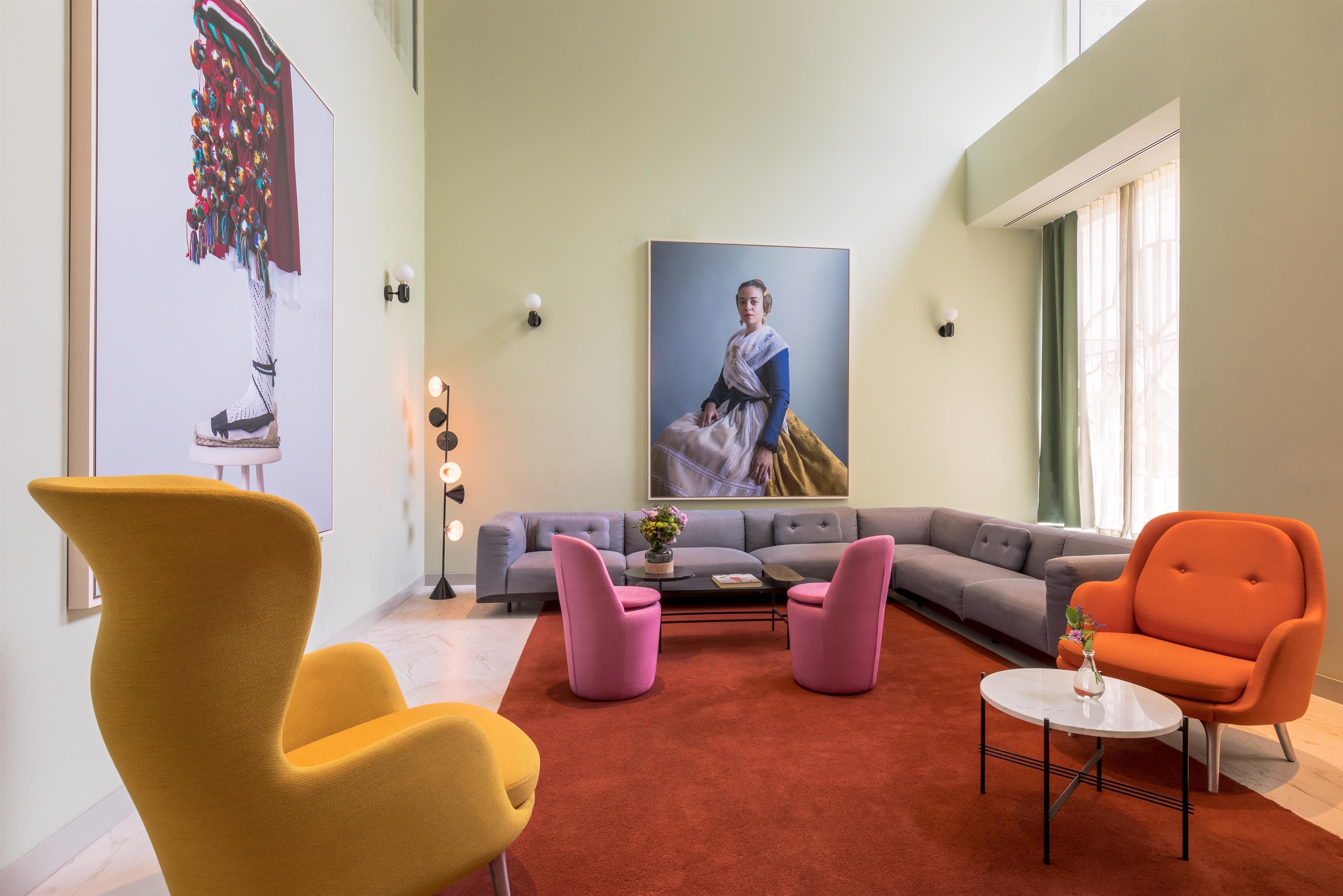 Ein modernes Wohnzimmer mit einem Ecksofa, einem gelben Sessel und einem orangen Sessel sowie einem Couchtisch.