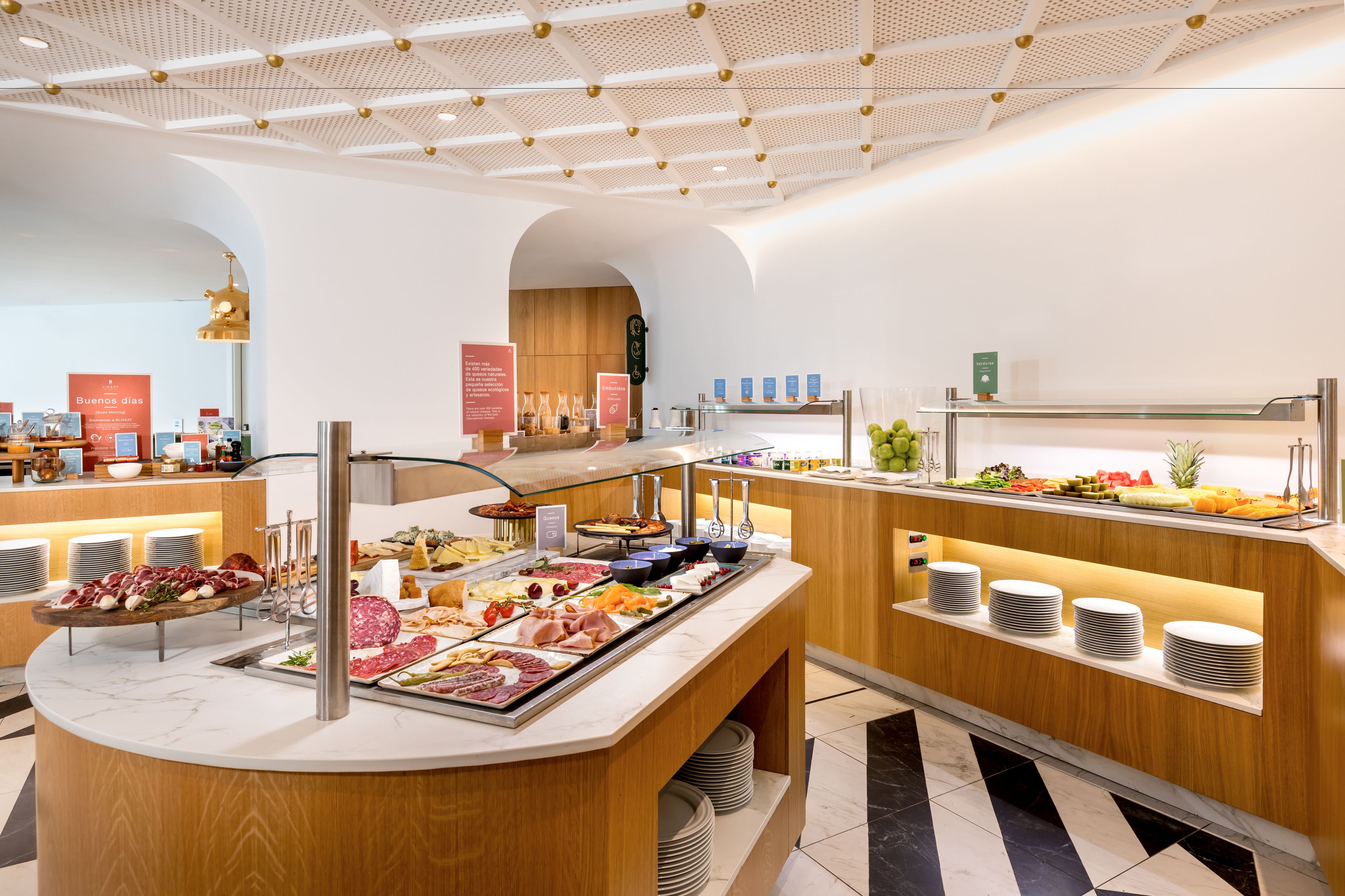 A buffet area with various food items and a modern interior design.