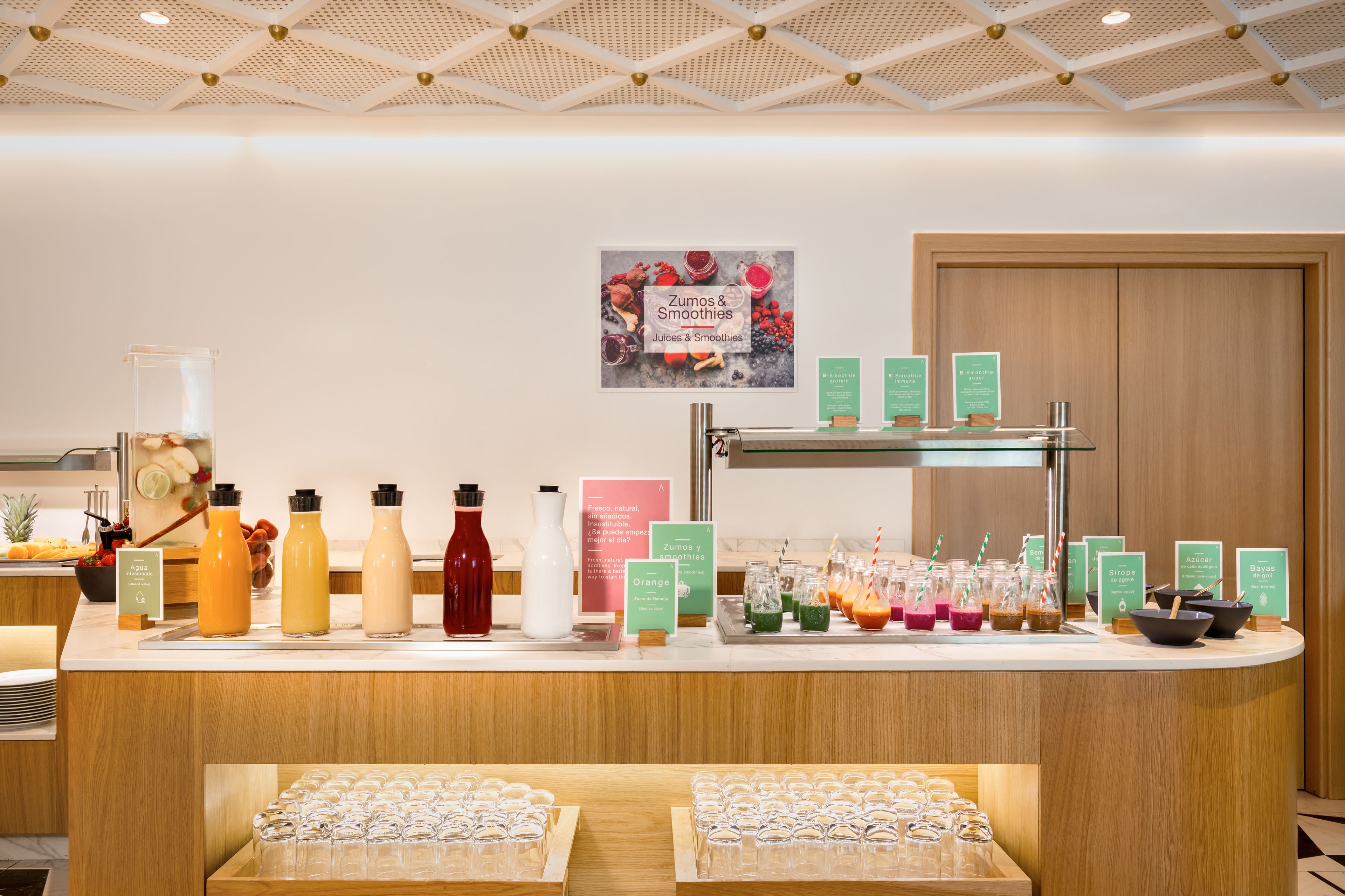 Un bar con distributori di succhi e frullati, e un cartello che recita 'Zumos & Smoothies'.