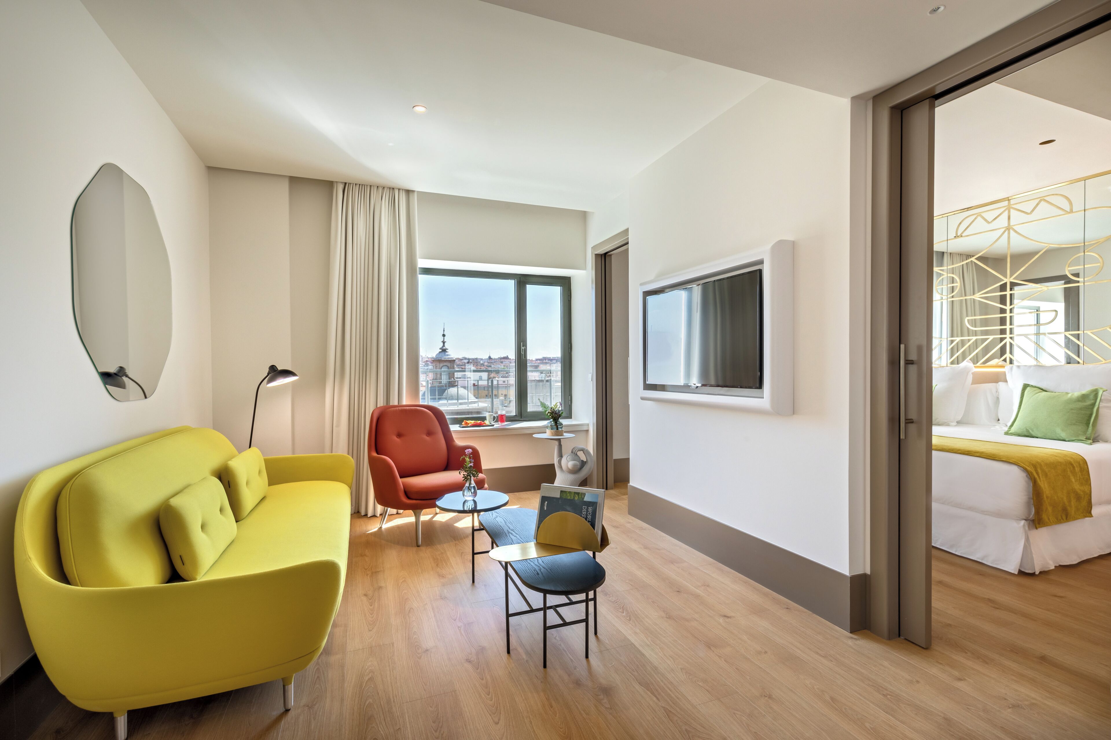 Habitació d'hotel amb sofà, butaca, taula petita i llit.