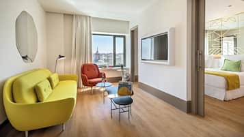 Habitació d'hotel amb sofà, butaca, taula petita i llit.
