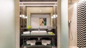 A modern bathroom with a large mirror, a sink, and a shower.