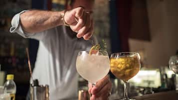 A bartender preparing drinks in a bar setting.