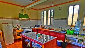 A kitchen with a central island, a refrigerator, a stove, and a sink. - Hotel El Sol (Panajachel)