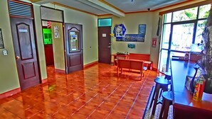 A spacious lobby with a tiled floor, a reception desk, and a seating area. - Hotel El Sol (Panajachel)