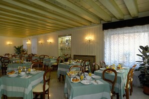 A dining area with tables set for breakfast, featuring breakfast items and a view of the room. - Basilea (Venice)