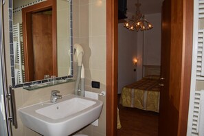 A bathroom with a sink, mirror, and towel rack. - Basilea (Venice)