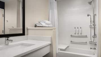 Un baño moderno con un lavabo blanco, espejo y ducha.
