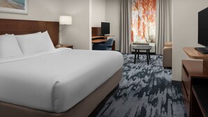 A hotel room with a large bed, a desk with a computer, a chair, a television, and a window with curtains. - Fairfield Inn & Suites by Marriott Panama City Beach (Panama City Beach)