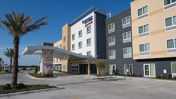 A Fairfield Inn & Suites hotel with a modern design, featuring a covered entrance and a parking lot.