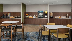 A hotel dining area with a counter, seating, and a refrigerator. - Fairfield Inn & Suites by Marriott Panama City Beach (Panama City Beach)