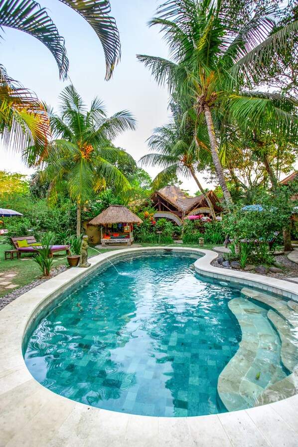 Una piscina al aire libre, tumbonas