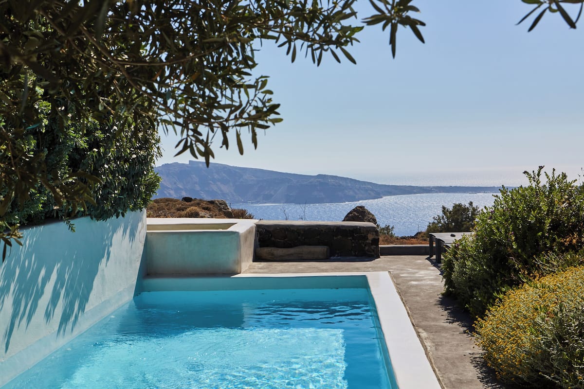 A swimming pool with a view of the sea and mountains.