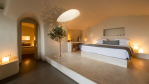 Een moderne slaapkamer met een groot bed, nachtkastjes, een kleine plant en een opvallend plafondontwerp.