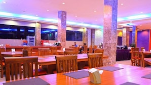 A spacious restaurant with wooden tables and chairs, large pillars, and a modern interior design. - Grand Inn Hotel Mataram (Mataram)