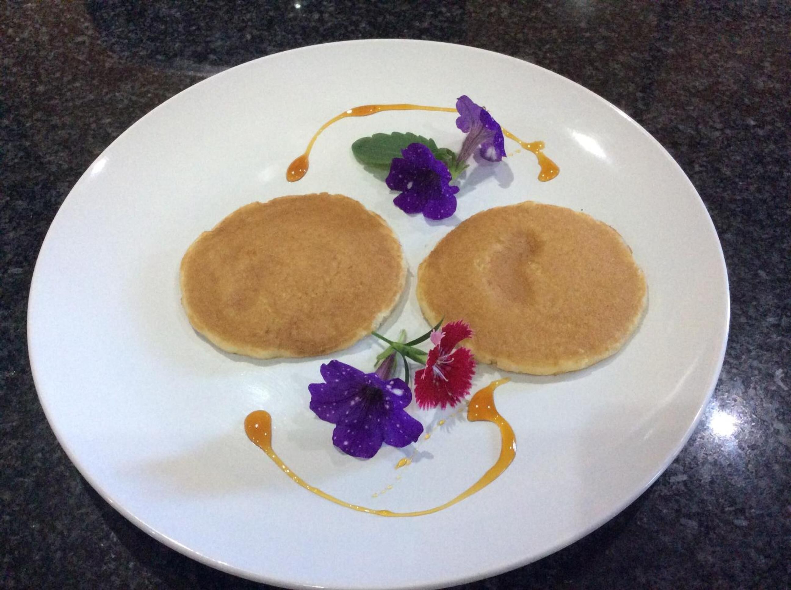 Een bord met twee pannenkoeken en decoratieve elementen.