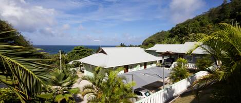 A coastal resort with multiple buildings, lush greenery, and a view of the ocean.