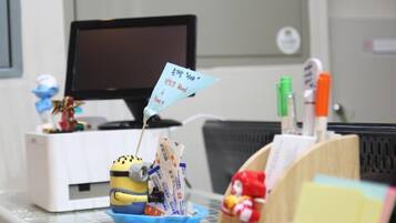 A desk with a small figurine of a minion, a toy ship, and various office supplies.