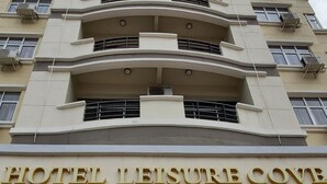 A multi-story hotel with a sign reading "HOTEL LEISURE COVE." - Leisure Cove Hotel & Apartments (George Town)