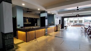 A reception area with a counter, a ceiling fan, and a view of the street outside. - Leisure Cove Hotel & Apartments (George Town)