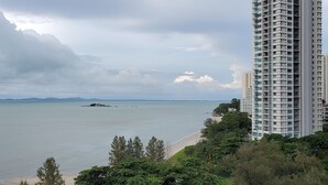 A coastal view with a beach, a large body of water, and a tall building. - Leisure Cove Hotel & Apartments (George Town)