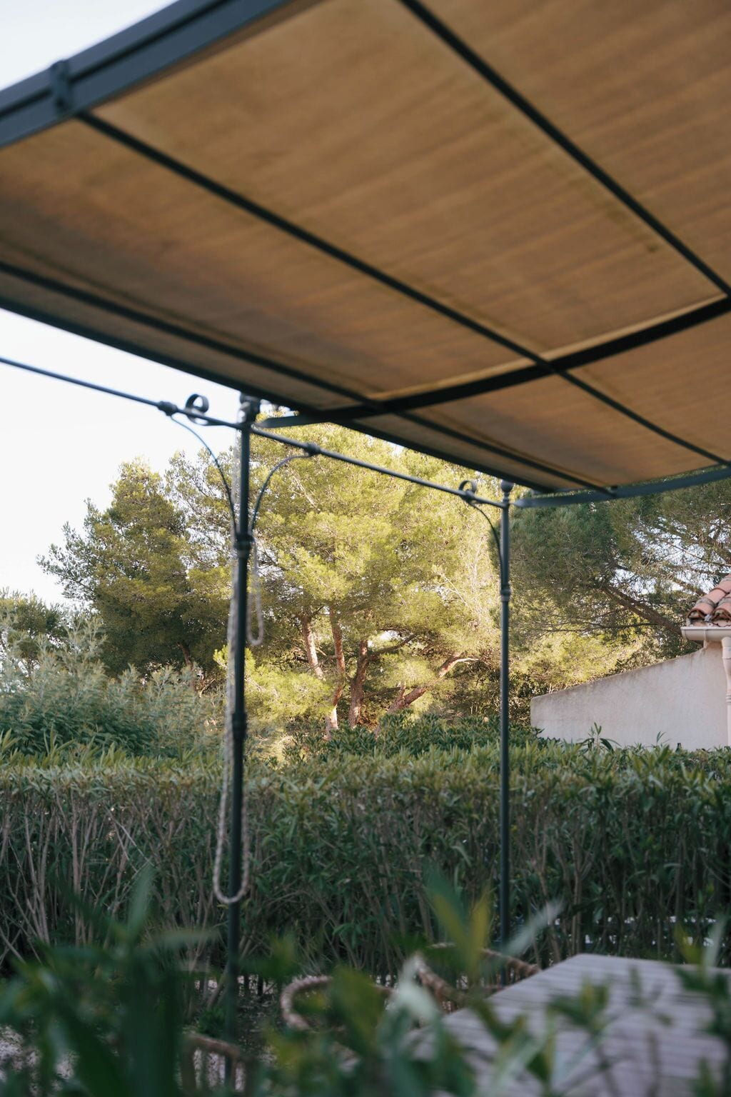 Un espace extérieur abrité, doté d’une structure métallique et d’un toit en bois.