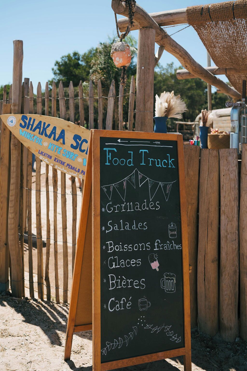 Un camion-restaurant proposant un menu écrit à la craie, avec des plats comme des salades, des viandes grillées et des boissons.