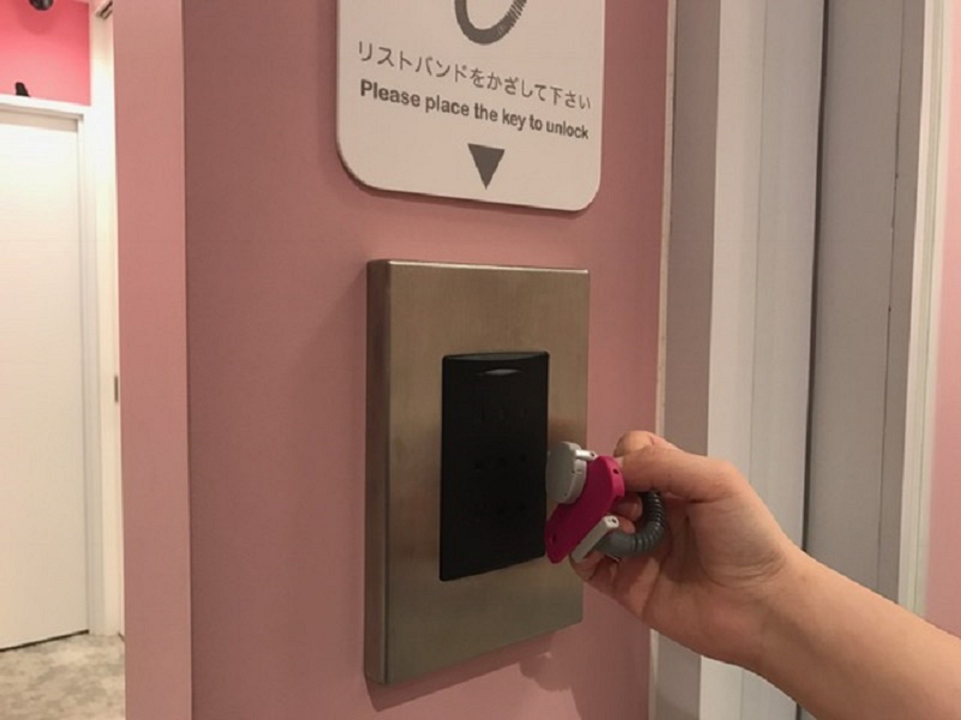 A hand placing a key into a lock on a door.