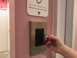 A hand placing a key into a lock on a door.