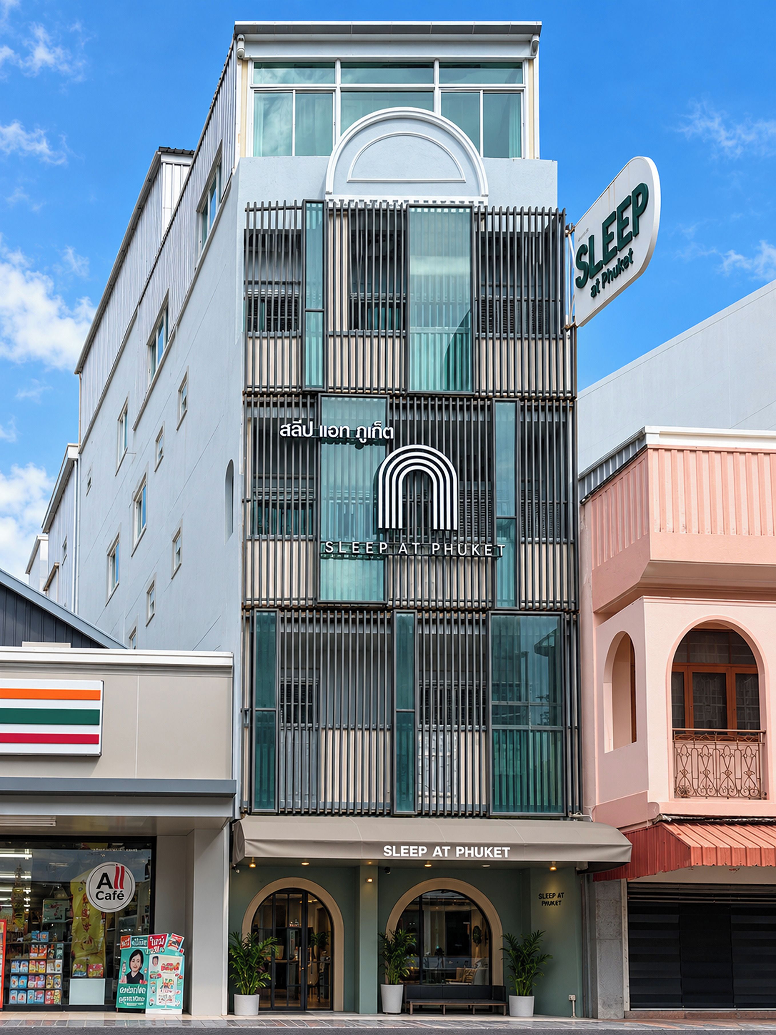 A building with a sign reading 'SLEEP AT PHUKET' and a café sign below.