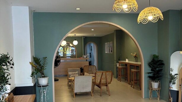 A spacious interior with a central archway leading to a dining area, a kitchen, and a bar area. - Sleep at Phuket (Phuket)