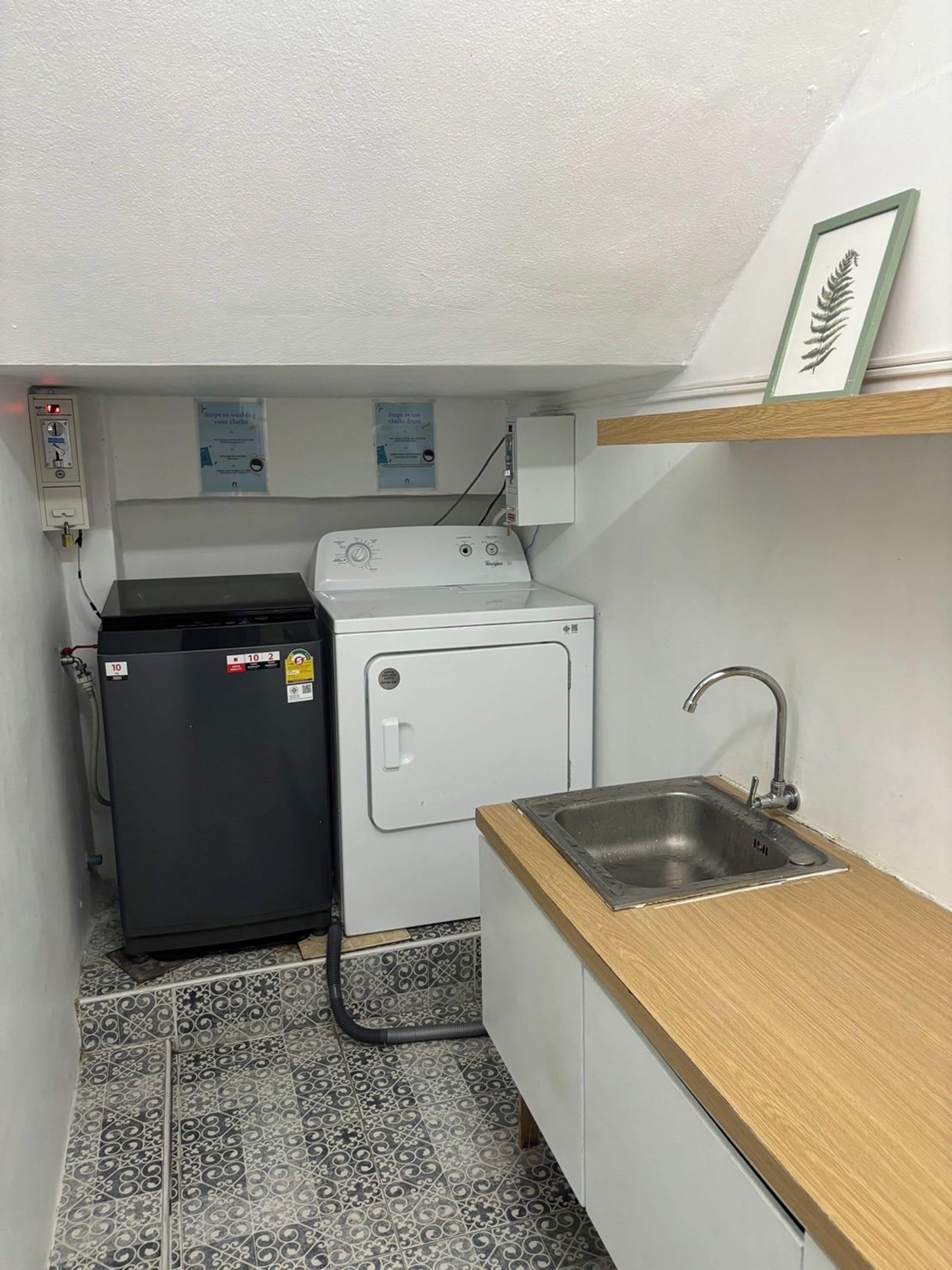 A compact kitchen with a washing machine, a sink, and a small countertop.