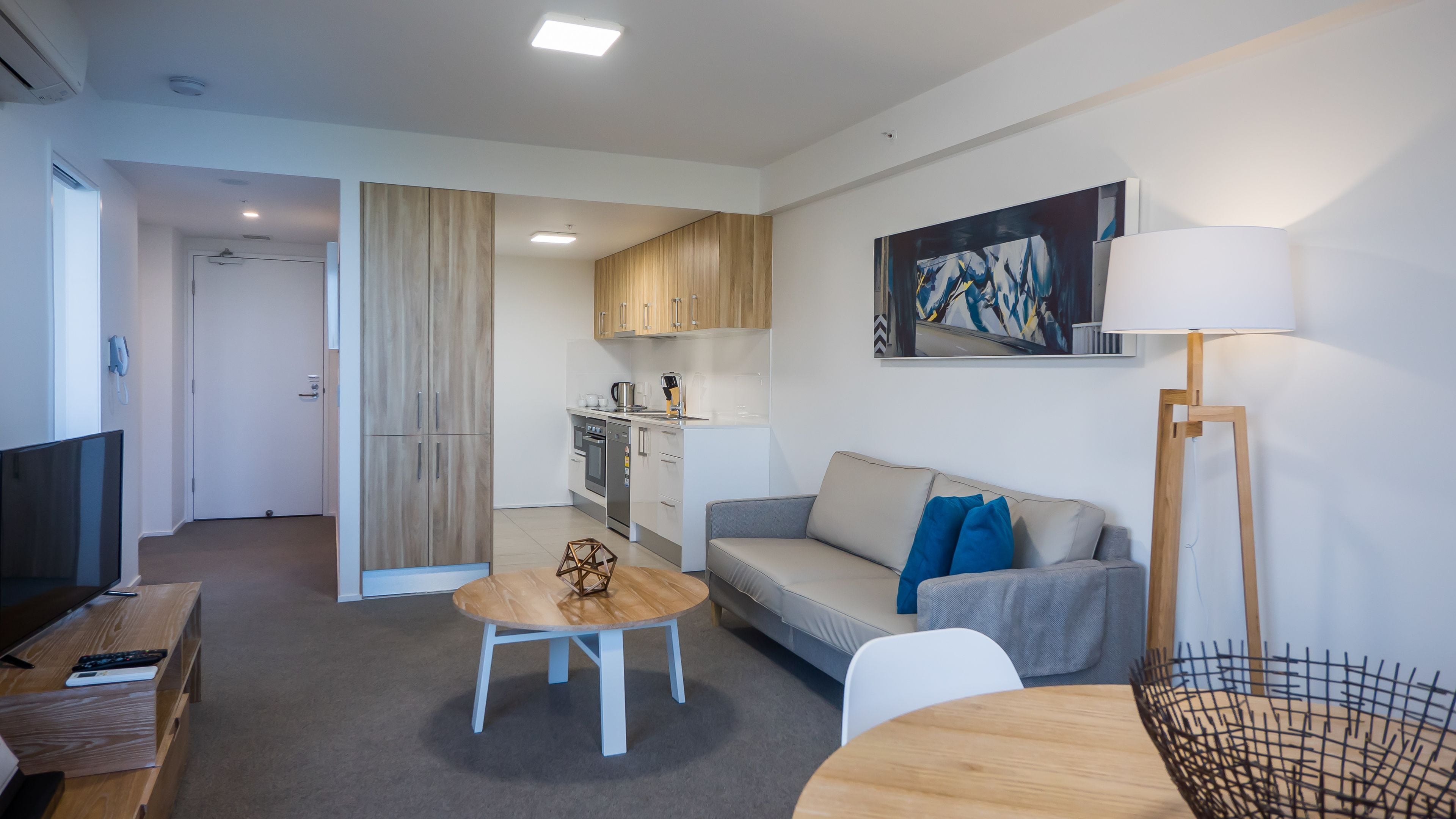 A modern apartment with a living room, kitchen, and dining area.