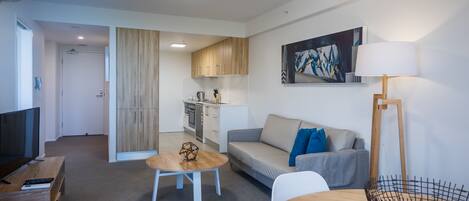A modern apartment with a living room, kitchen, and dining area.